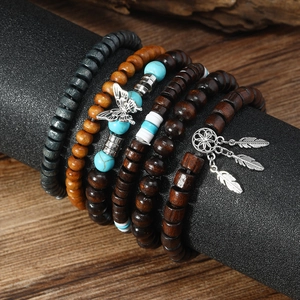 Detail of multi-layer beaded bracelets with butterfly and dreamcatcher feather charms
