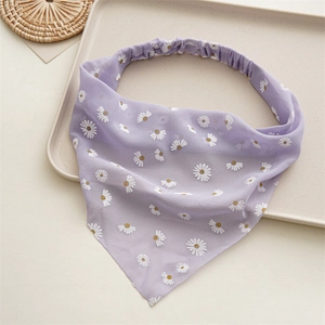 Close-up of a purple floral chiffon hair scarf with white daisy prints on a tray