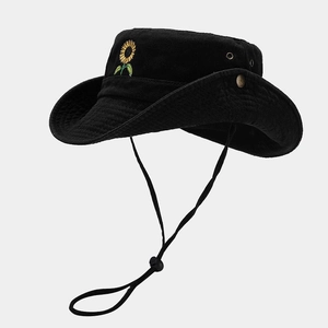 Detail of black cotton bucket hat showing sunflower embroidery and side metal snap button