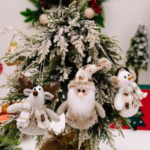 Detailed view of plush reindeer and snowman ornaments on a snowy Christmas tree