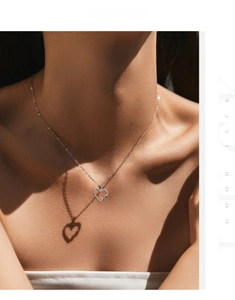 S925 silver heart necklace with infinity symbol and crystals casting a heart shadow