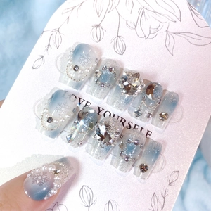 Detail of long gradient blue snowflake press-on nails with pearls and sequins