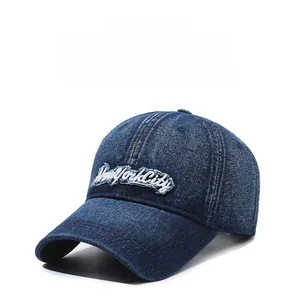 Detail of New York City white embroidery on vintage navy denim baseball cap with distressed brim