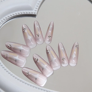 Cat eye press-on nails with silver star patterns and rhinestones on long stiletto tips