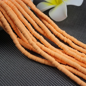 Detail view of orange polymer clay heishi beads for DIY handmade bracelet jewelry