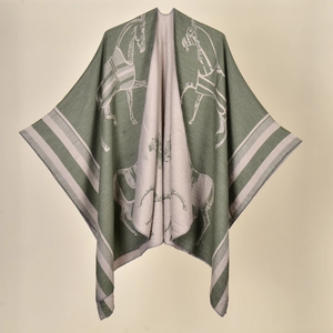 Detail of green and beige reversible knit shawl with horse patterns and striped trim