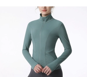 Détail des passe-pouces et du zip sur cette veste de sport de yoga ajustée verte