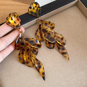Detailed view of translucent amber tortoiseshell acrylic petal tassel earrings on display