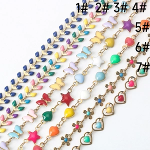 Détail de breloques colorées papillon et cœur sur maillons de chaîne DIY en acier inox