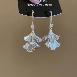 Silberne Ginkgoblatt-Ohrhänger mit funkelnden Zirkonia-Steinen auf Display-Karte
