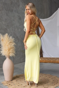Detail of yellow backless maxi dress featuring criss-cross lace-up straps and slim fit cut