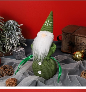 Macro view of a green knitted Christmas gnome candy bag with white plush beard and drawstring