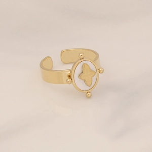 Detail of adjustable gold ring with white oval inlay and star-shaped flower engraving