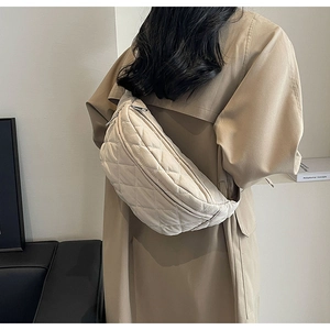 Beige quilted crescent crossbody bag shown worn to demonstrate size and stylish fit