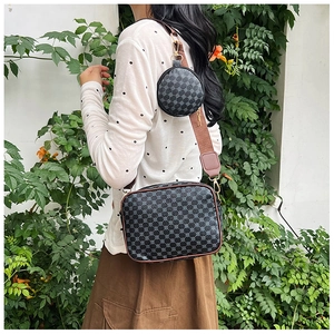 Detailed view of dark grey geometric print crossbody bag with detachable mini round pouch
