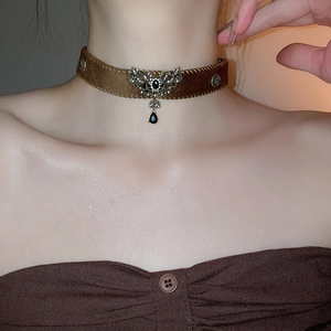 Detail of vintage brown velvet choker with rhinestone butterfly and black pendant