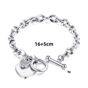 Macro shot of a silver heart charm bracelet with OT toggle clasp and 16+5cm size label