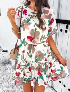 Dettaglio del vestito floreale bianco a maniche corte con balze e borsa di paglia estiva
