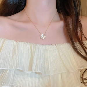 Dettaglio della collana a farfalla in zircone su modella con ciondolo in madreperla