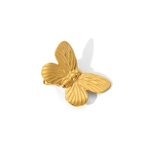 Makro-Detail der goldenen Schmetterlings-Haarklammer mit elegantem Metallglanz auf Weiß