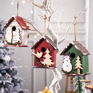 Three wooden Christmas birdhouse ornaments with snowmen and pine berry decorations
