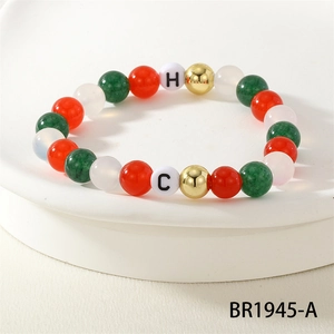 Close-up of color-block pearl bracelet with red, green, and gold festive holiday beads