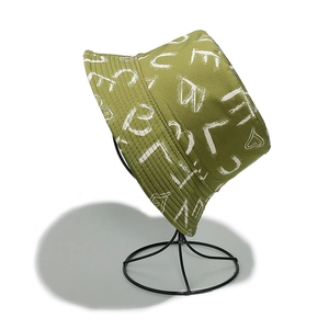 Dettaglio cappello a secchiello in cotone verde con stampa LOVE bianca e graffiti