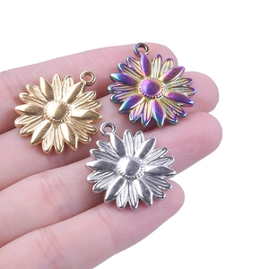 Three sunflower stainless steel pendants in gold, silver, and rainbow colors held on a palm