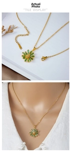Detail of golden daisy necklace with green stone inlay and lobster clasp on steel chain