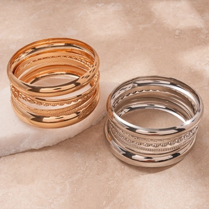 Eight-piece geometric metal bangle set in gold and silver with various textures