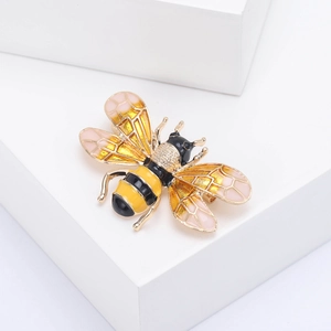 Close-up of a bee brooch featuring gold plating with colorful enamel and crystal wings