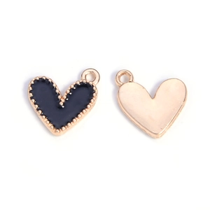 Detail of heart-shaped alloy pendants with black and gold enamel finish for jewelry making