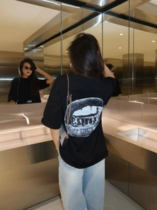 Minimalist black oversized T-shirt for women featuring back lip print and drop shoulder design
