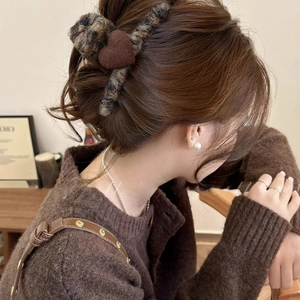 Brown leopard print flocked heart hair claw clip shown on model in warm home setting