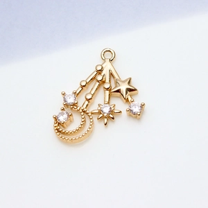 Macro detail of gold-plated star and moon pendant with shimmering cubic zirconia inlay