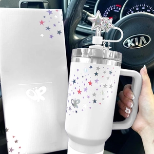 Star pattern Stanley cup accessory with bow charms and matching gift box in car interior