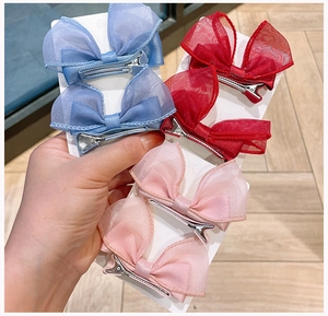 Detailed view of handmade mesh butterfly hair clips in blue, red and pink pastel colors