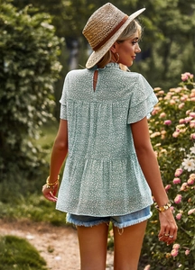 Rear view of light green floral blouse with ruffle sleeves and layered hem detail
