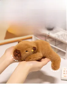 Close-up of a small palm-sized brown capybara plush toy with soft fluffy texture