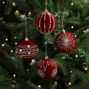 Set of four 8cm burgundy flocked Christmas balls with gold bead patterns on a tree