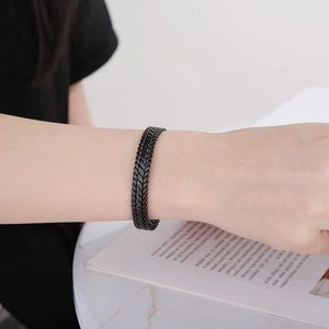 Detail of 9mm matte black stainless steel woven cuff bracelet on model wrist