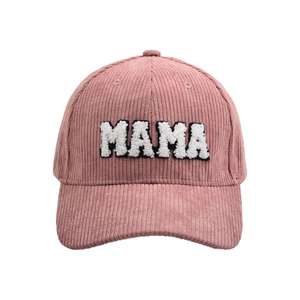 Close-up of pink corduroy baseball cap featuring plush MAMA embroidery and fabric texture