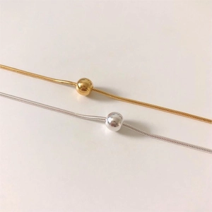 Close-up of minimalist S925 sterling silver gold and silver snake chains with sliding beads