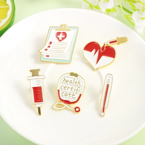 Five-piece medical enamel brooch set with stethoscope, syringe, and heart on a white tray