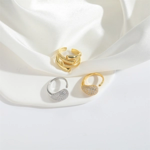 Minimalist teardrop open rings set in gold and silver with textured layered design