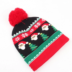Close-up of knit texture with Santa Claus and snowflake patterns on a Christmas beanie