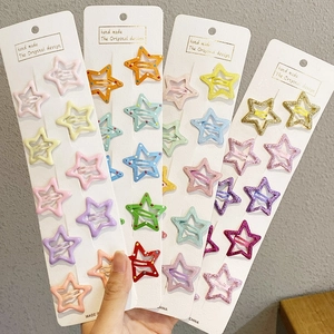Close-up of candy-colored star hair clips with glitter finish on a white card