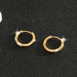 Macro shot of gold-plated S925 sterling silver huggie earrings with brilliant zircon stones