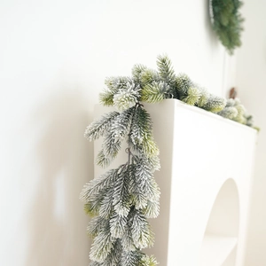 Christmas garland with artificial green pine needles and white flocked snow for home decor