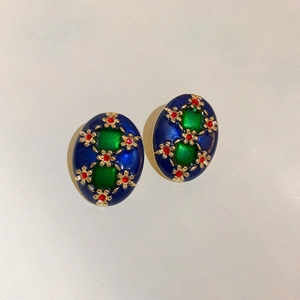 Close-up of vintage oval floral earrings with deep blue enamel and golden petals
